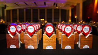 A row of ESTO 2023 Awards On A Table